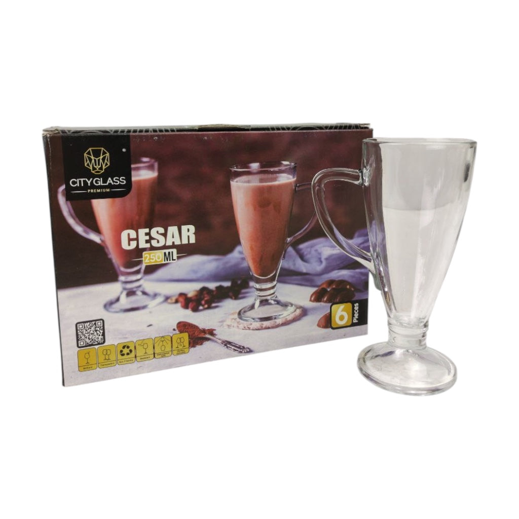 Clear glass mug with red liquid next to its packaging on a white background