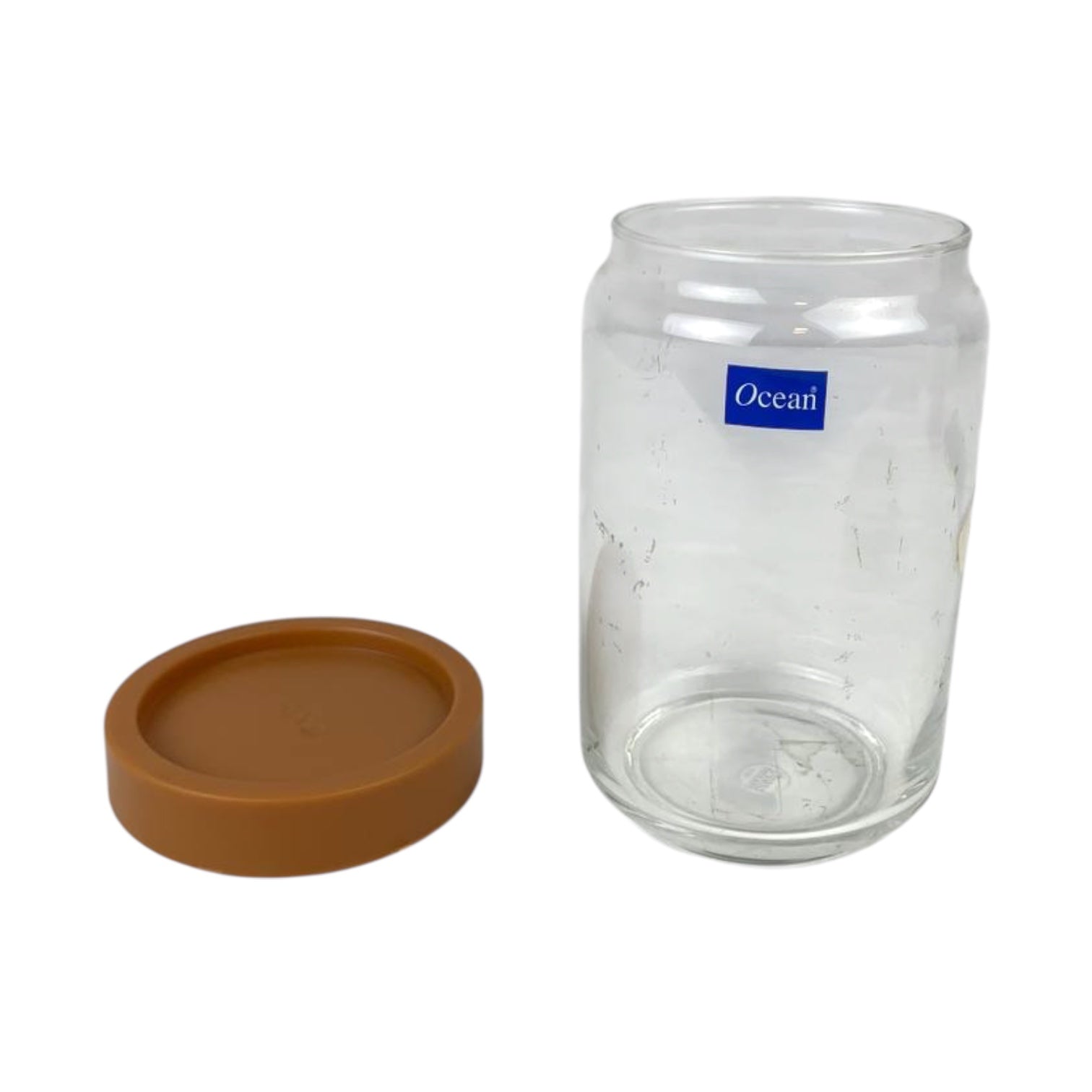 Clear glass jar with a brown lid on a white background