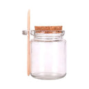 Mini glass jar with cork lid and wooden spoon for storing spices or honey