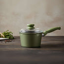 Green saucepan with lid on a wooden surface