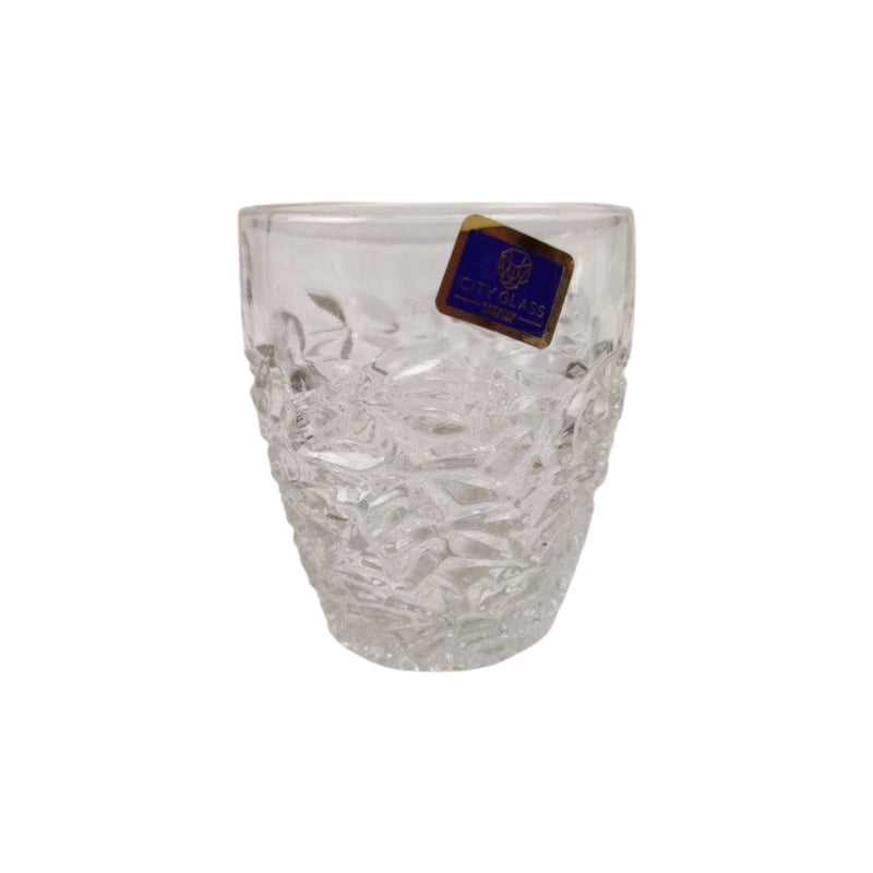 Clear glass vase with a brand label on a white background