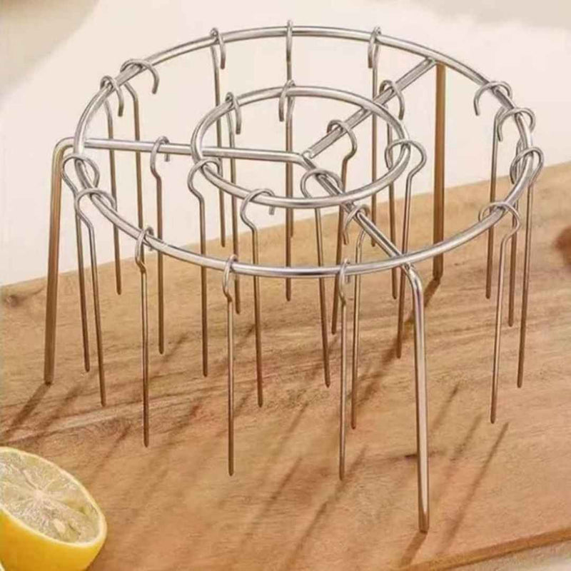 Metal plant support stake on a wooden surface with a lemon