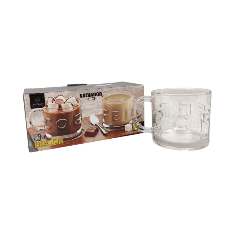 Clear glass mug with handle and embossed design next to its packaging on a white background