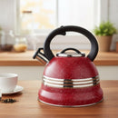 Red speckled kettle with black handle on a wooden surface