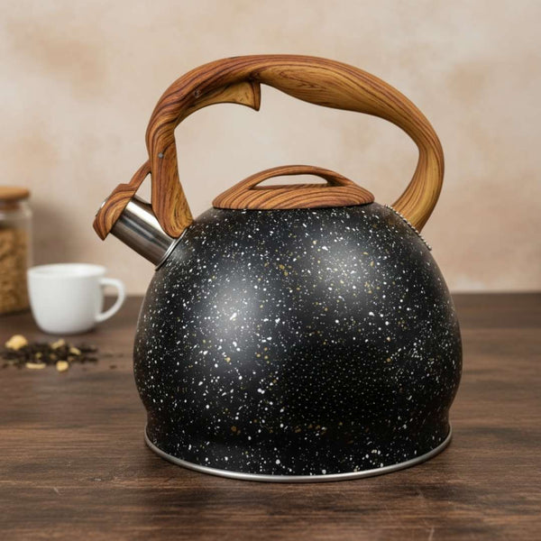 Black speckled kettle with wooden handle on a wooden surface