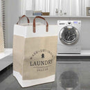 Beige laundry bag with 'Wash Dry Iron Laundry Deluxe' text in a laundry room.