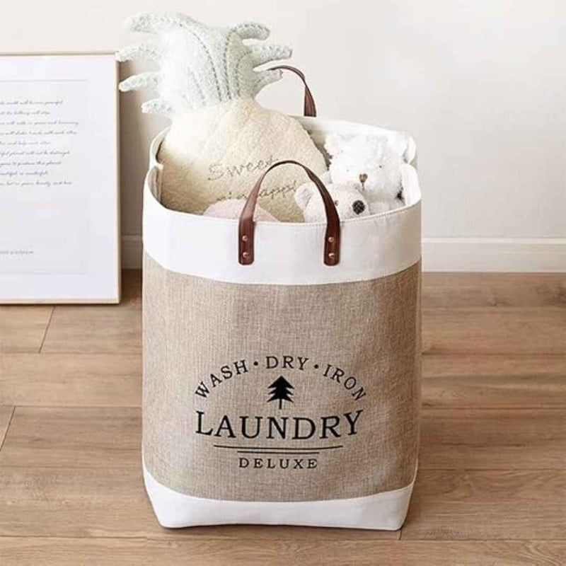 Laundry basket with handles on a wooden floor, containing stuffed animals.