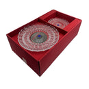 Decorative glass plate with intricate design in a red box on a white background