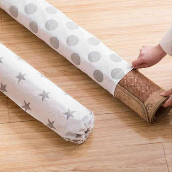 Two rolls of wallpaper with star and polka dot patterns on a wooden floor.