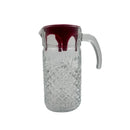 Clear glass pitcher with a red interior on a white background