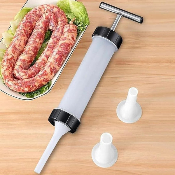 Sausage stuffer with three additional parts on a wooden surface next to raw sausages.