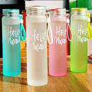 Four colorful water bottles with 'Hello Master' text on a wooden surface.