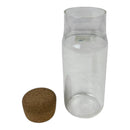 Clear glass container with a cork stopper on a white background