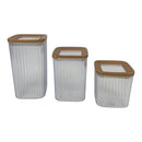 Three clear storage containers with brown lids on a white background