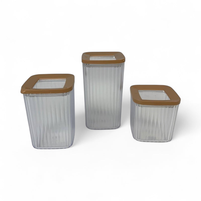 Three clear storage containers with brown lids on a white background