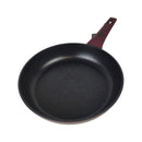 Black frying pan with a red handle on a white background