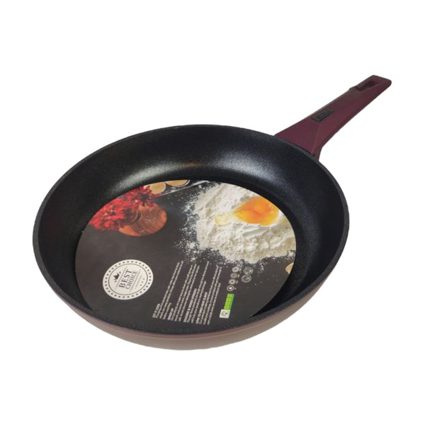 Black frying pan with a decorative label on a white background