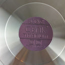 Close-up of a purple 'Cenk Titanium' label on a metallic surface