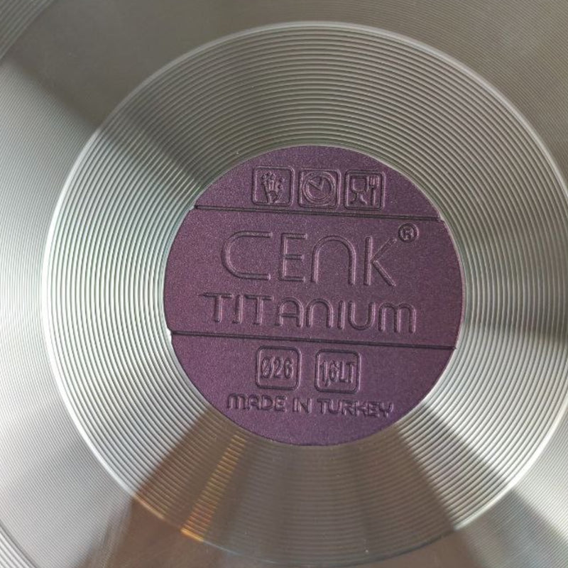 Close-up of a purple 'Cenk Titanium' label on a metallic surface