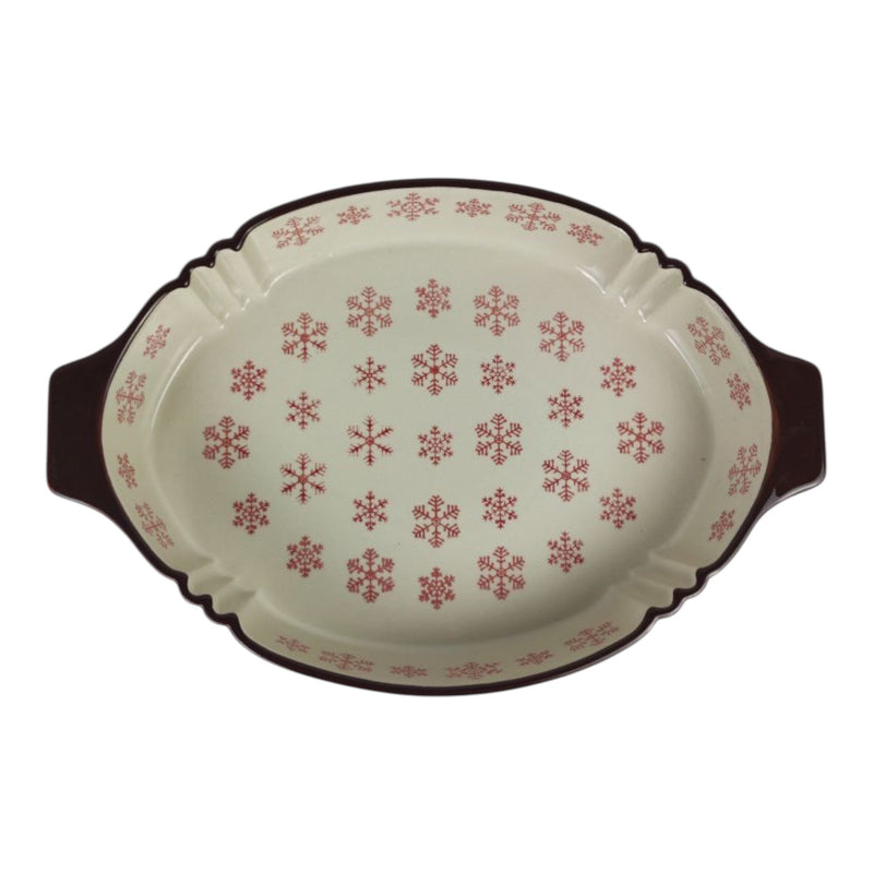 Decorative oval platter with red snowflake pattern on a white background