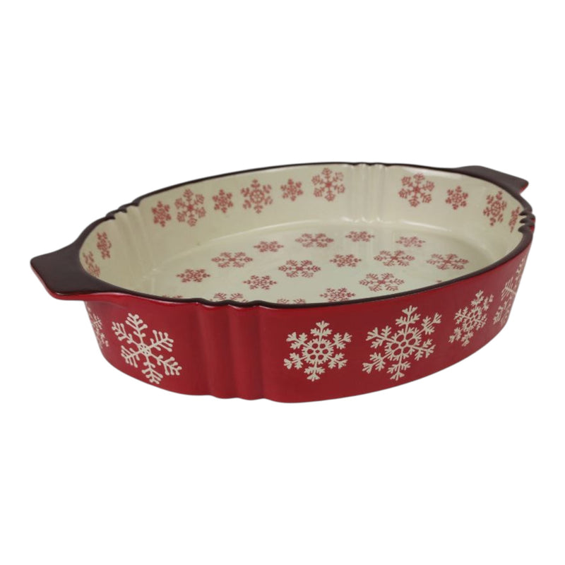 Red ceramic baking dish with snowflake patterns on a white background