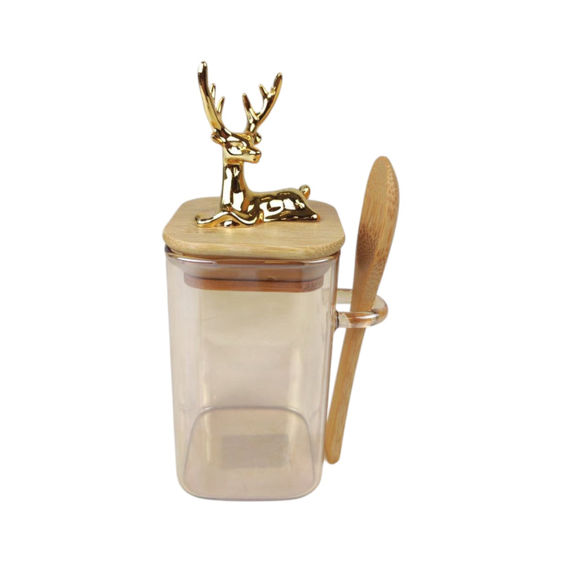 Clear container with gold deer lid and wooden spoon on a white background