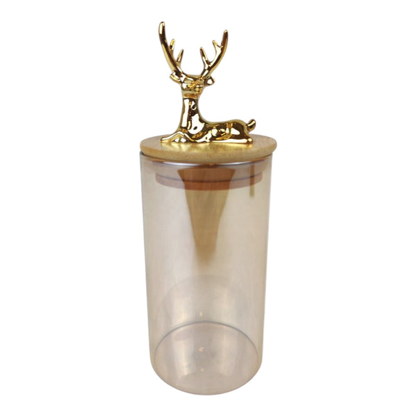 Clear tumbler with a gold deer figurine on top against a white background