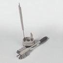 Set of kitchen cleaning brushes with a holder on a light gray background