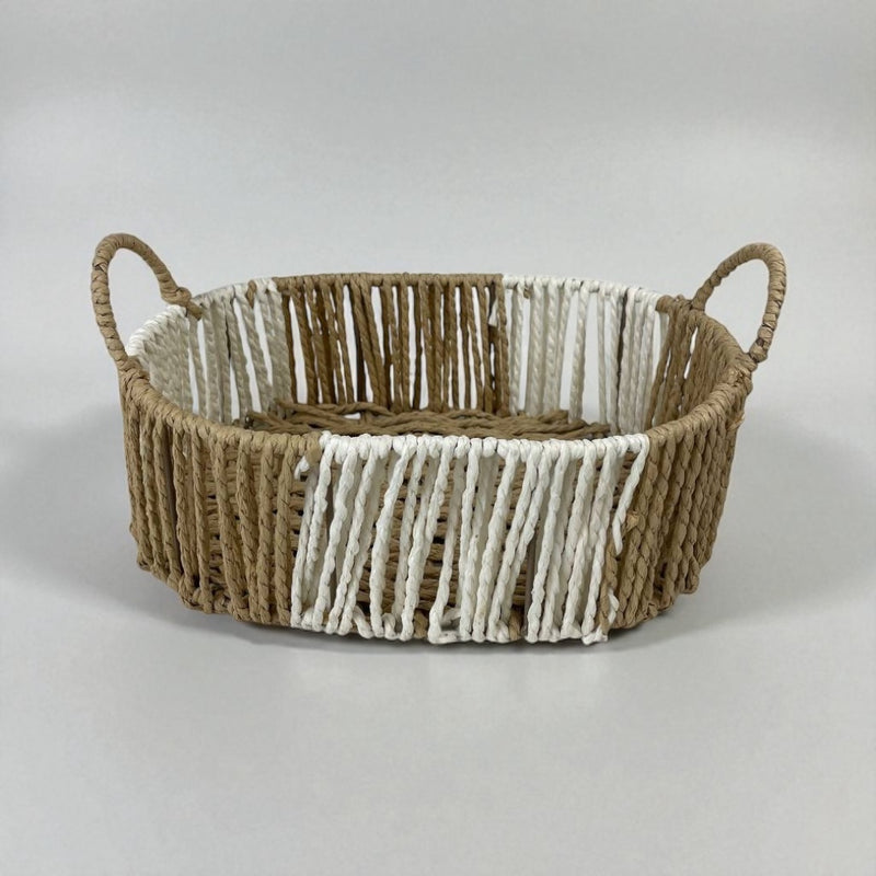 Woven basket with handles on a light gray background