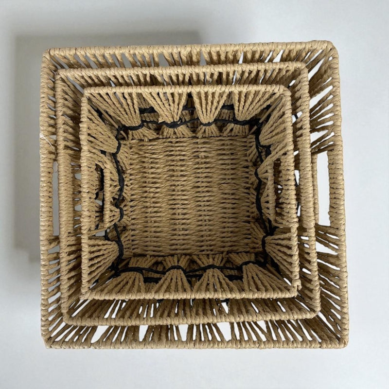 Set of three woven baskets of different sizes on a light gray background