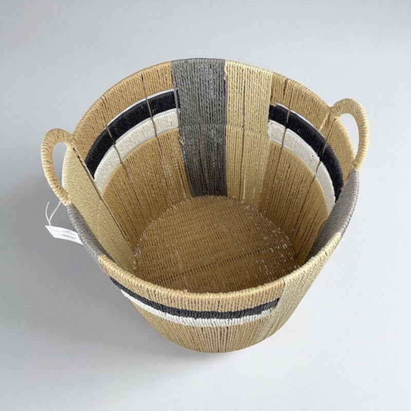 Woven basket with striped pattern on a light gray background