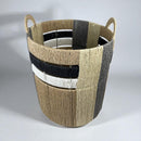 Woven basket with black, white, and beige stripes on a light gray background