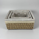 Set of three woven baskets with floral pattern on a gray background