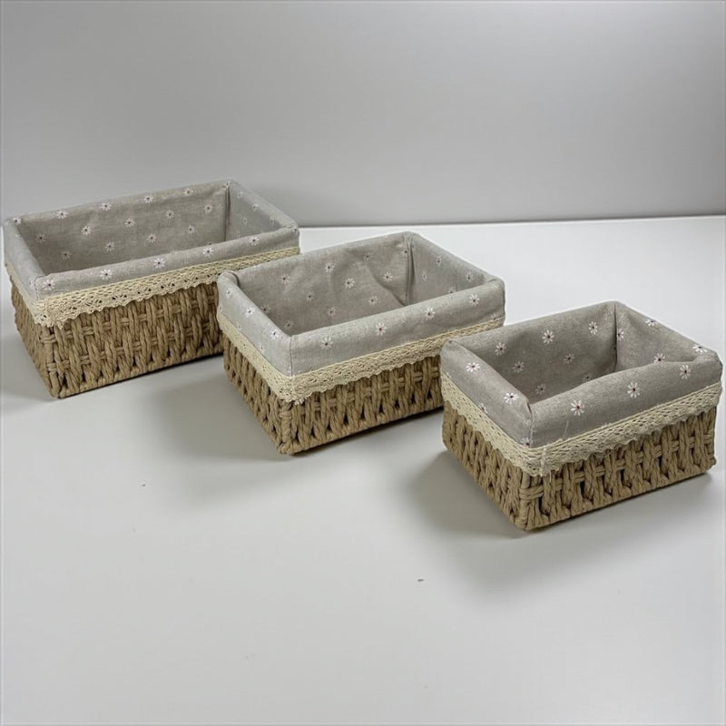 Three woven baskets with gray fabric interiors on a white surface
