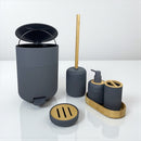 Bathroom accessory set with gray trash can, brush holder, and soap dispenser on a white background