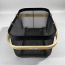 Black mesh basket with wooden handle on a light gray background