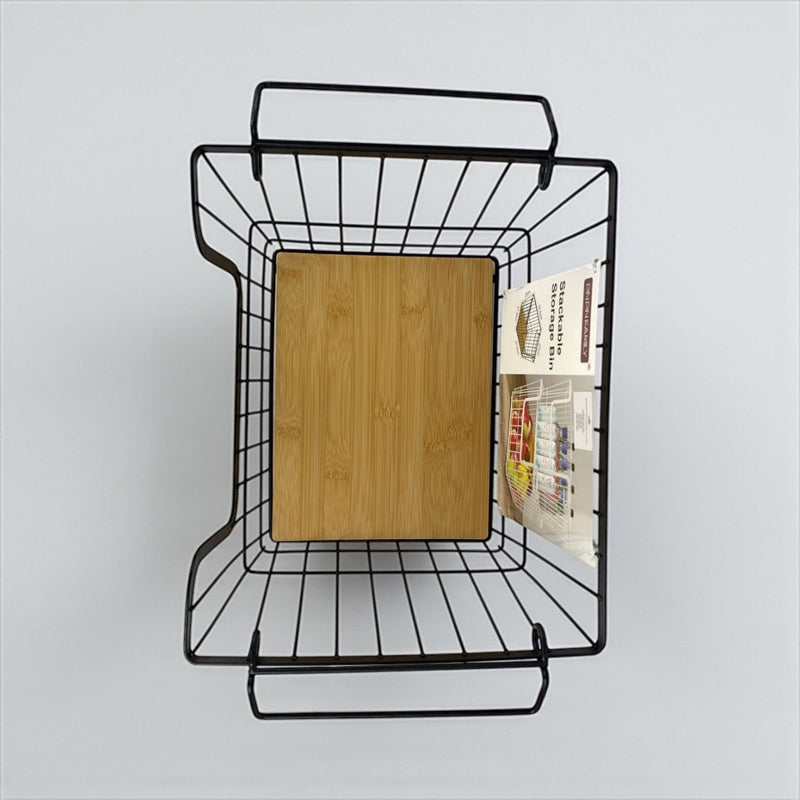 Wall-mounted metal basket with a wooden board and magazines on a light gray background