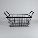 Black wire basket with handles on a light gray background