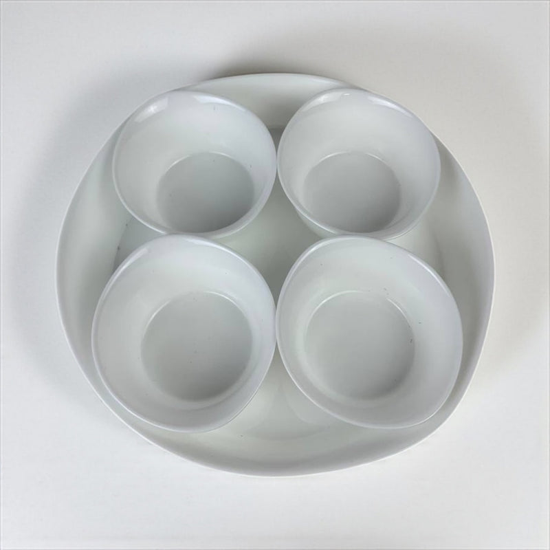 Round white tray with four compartments on a light gray background