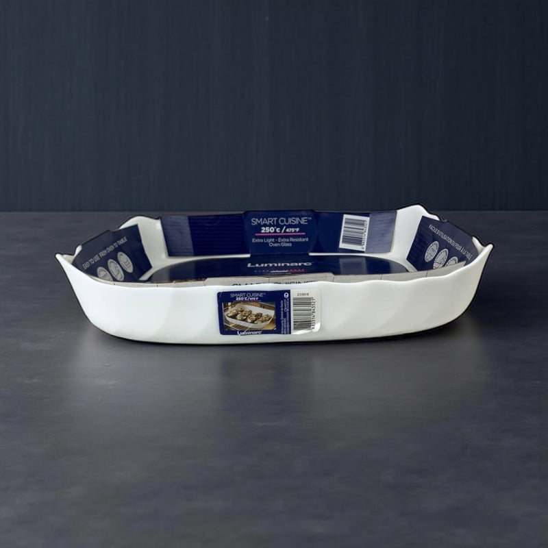 White ceramic baking dish with labels on a dark background