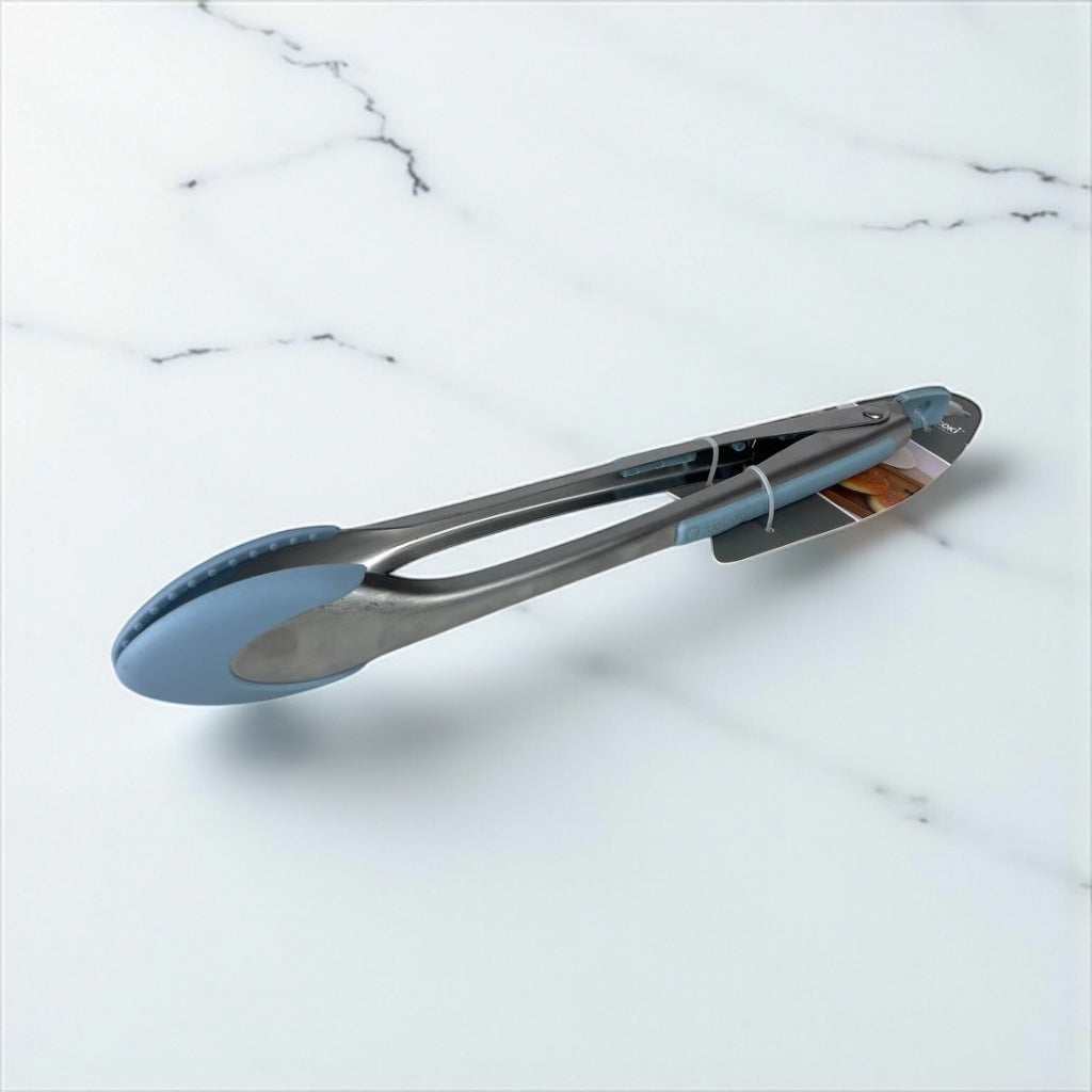 Metal tongs with blue silicone tips on a marble surface available at cupindy.com