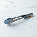 Metal tongs with blue silicone tips on a marble surface available at cupindy.com