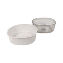 Two plastic kitchen utensils, one white with a perforated design and the other clear, on a white background.