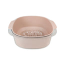 Pink colander with metal handle on a white background