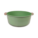 Green mixing bowl with copper handles on a white background