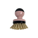Pink and black dish brush with beige bristles on a white background