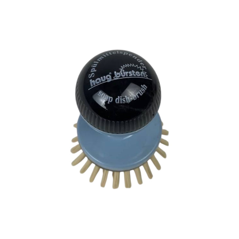 Soap dish brush with black top and blue body on a white background
