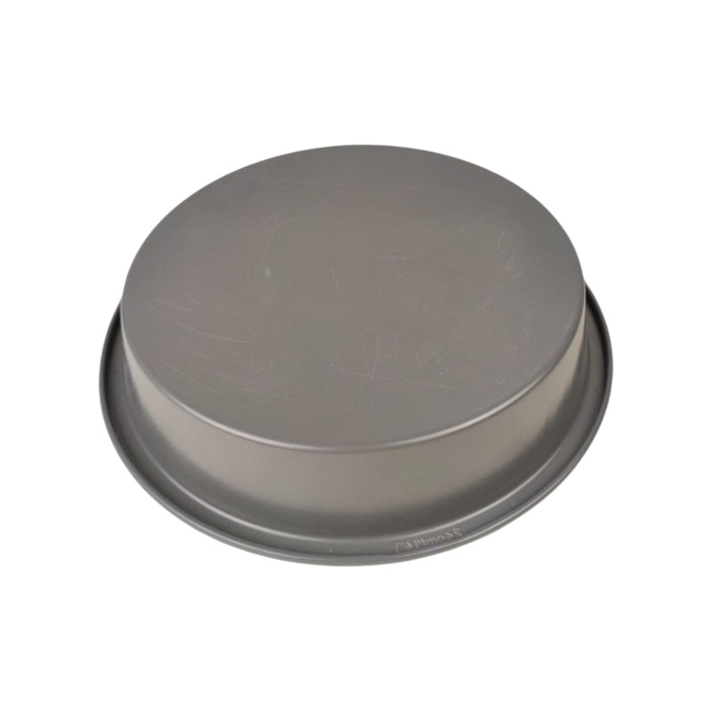 Round metal cake pan on a white background