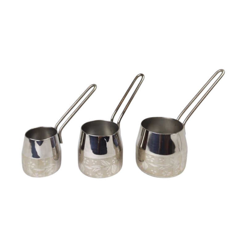 Three silver measuring cups with handles on a white background