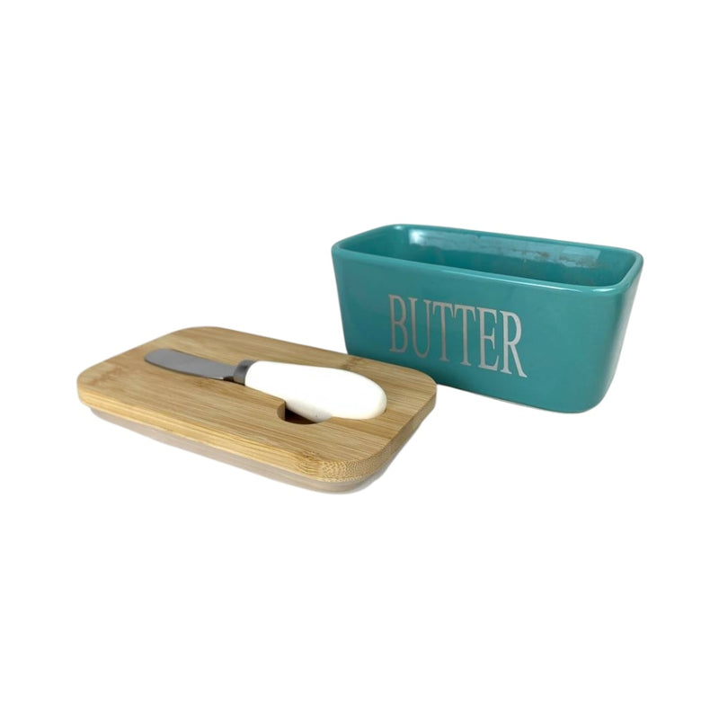 Teal butter dish with wooden cover and knife on a white background